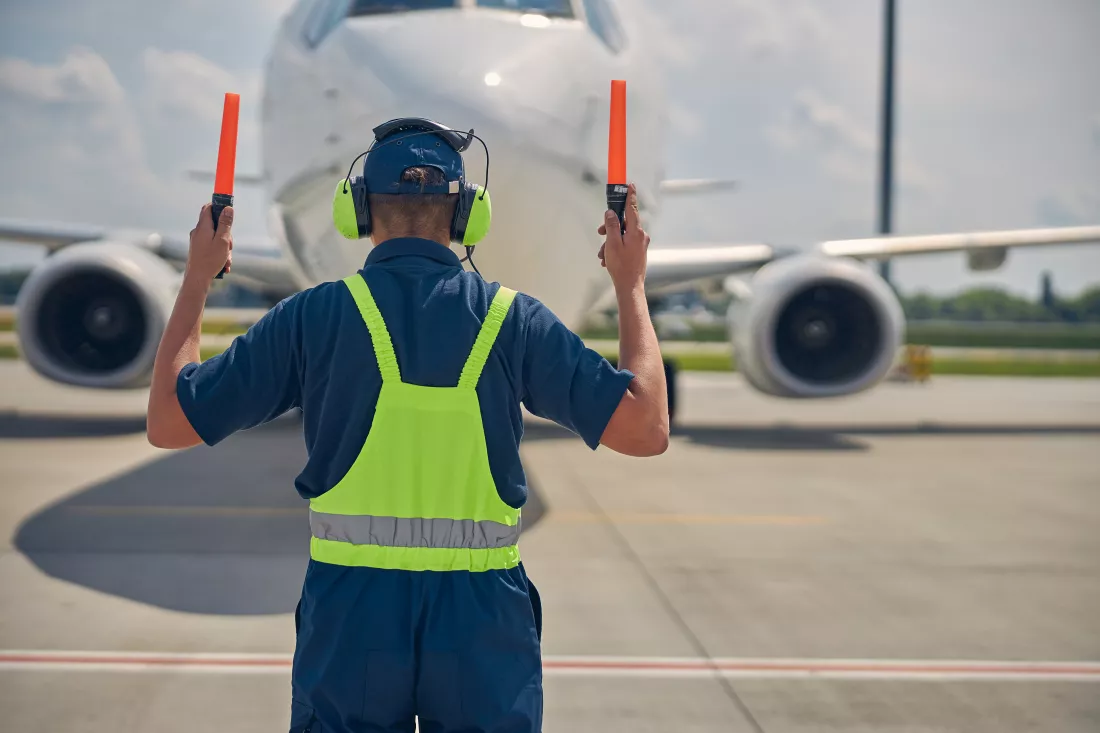back-view-aircraft-worker-making-move-ahead-signal-cockpit-crew